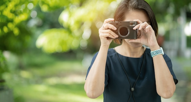 Asiatische Frau, die Fotos macht, Berufsfotograf