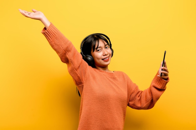Asiatische Frau, die gerne telefoniert und Musik hört Entspannung mit Musik An einem angenehmen Tag Tanz- und Entspannungskonzept, das online Musik hört
