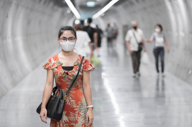 Asiatische Frau, die Gesichtsmaske trägt, schützt Coronavirus-Beugung