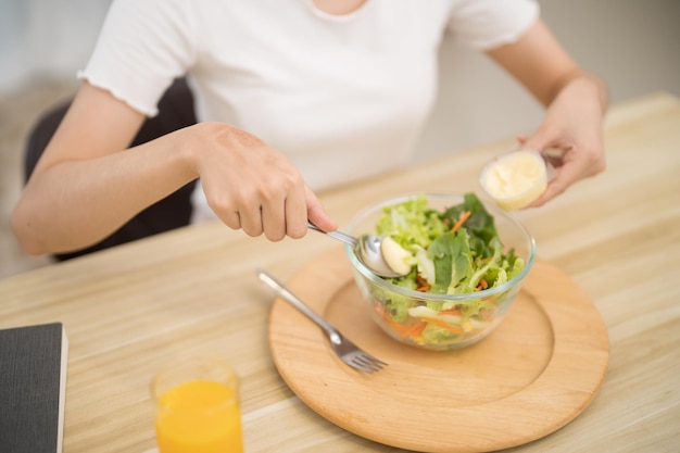 Asiatische Frau, die Gewichtsverlust isst und frische, hausgemachte Salate isst, gesundes Ernährungskonzept