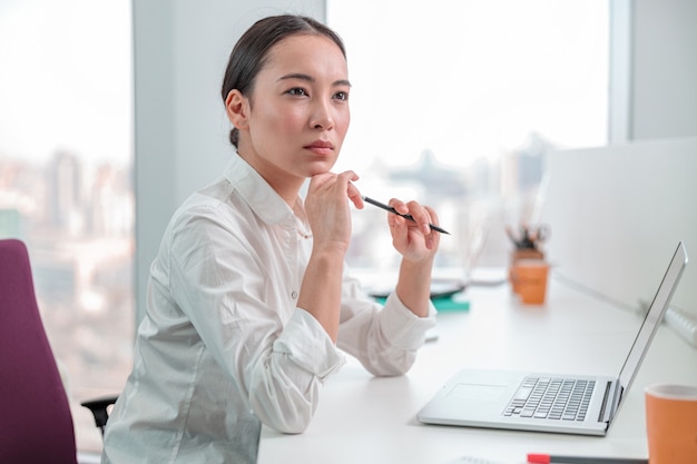 Asiatische Frau, die im IT-Büro arbeitet