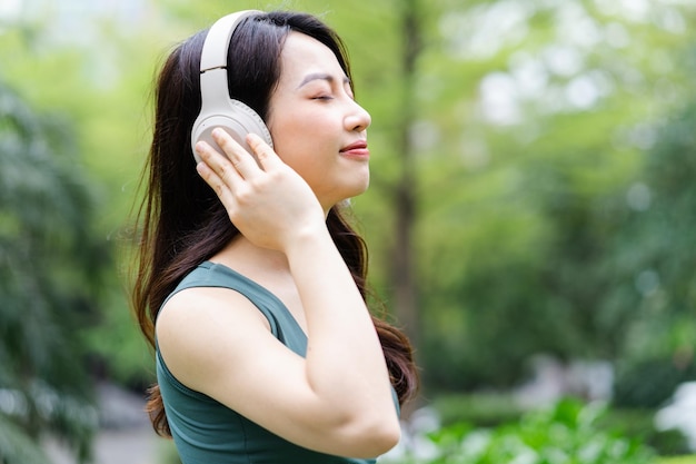 Asiatische Frau, die im Park trainiert