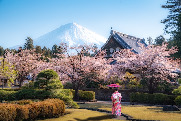 Asiatische Frau, die im Tempel mit Mt geht. Fuji in Japan