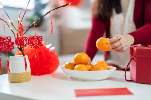 Asiatische Frau, die Mandarinen mit roter Geschenkbox hält, dankbares Geschenk Lunar New Year Chinese