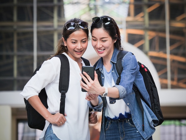 Asiatische Frau, die mit Handy reist