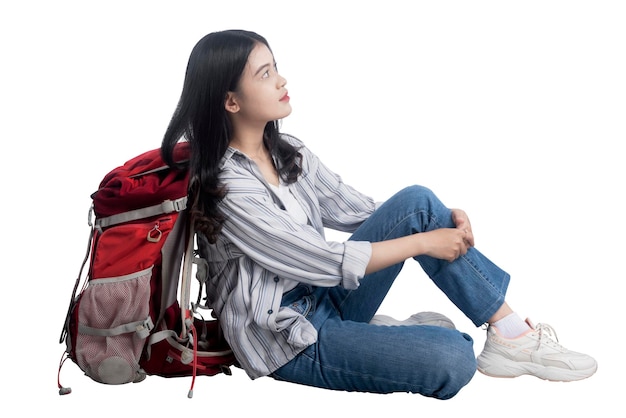 Asiatische Frau, die mit ihr einen Rucksack sitzt