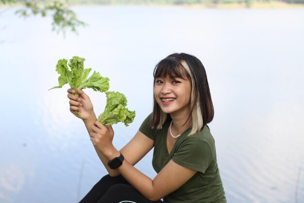 Asiatische Frau, die morgens Salat hält