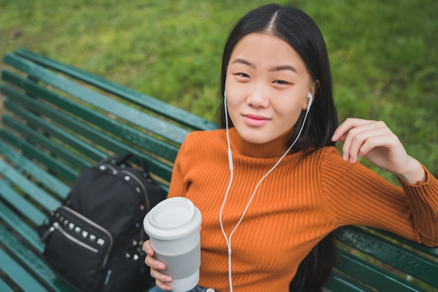 Asiatische Frau, die Musik hört.