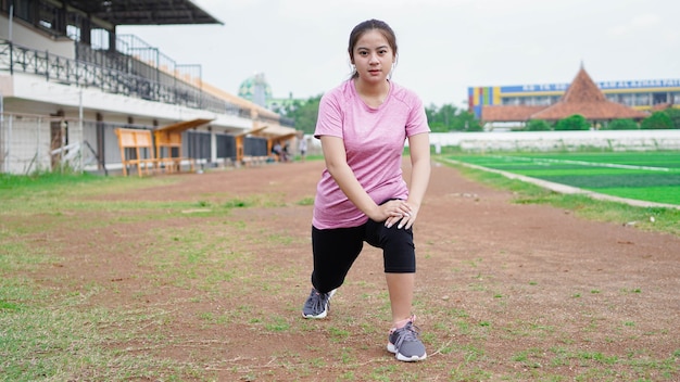Asiatische Frau, die sich vor dem Laufen aufwärmt