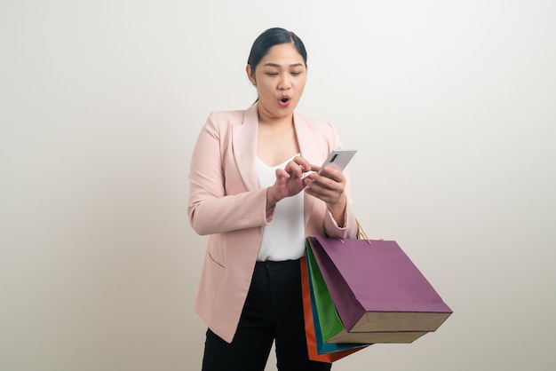 Asiatische Frau, die Smartphone mit Einkaufstasche verwendet Online-Shopping-Konzept