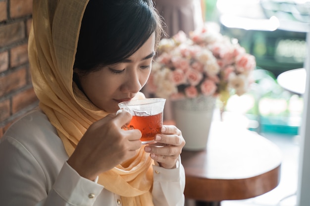 Asiatische Frau, die Tasse Tee genießt