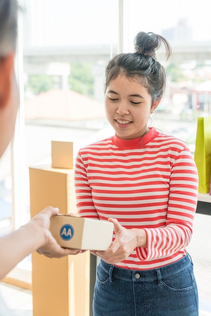 Asiatische Frau erhält Lieferpaket