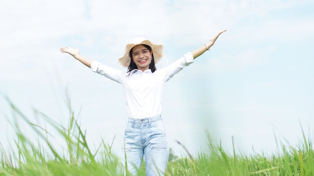 Asiatische Frau fotografiert in einem Feld mit grünem Reishintergrund glückliche Bäuerin