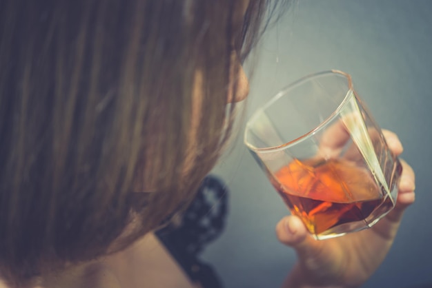 Asiatische Frau gebrochenes Herz mit Whiskey in der Hand auf Vintage-Stil
