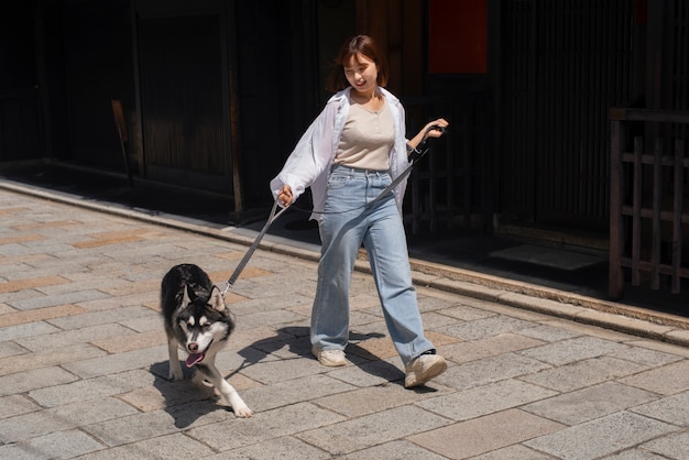 Asiatische Frau geht mit ihrem Husky-Hund im Freien spazieren