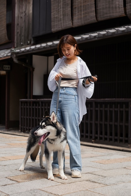 Asiatische Frau geht mit ihrem Husky-Hund im Freien spazieren