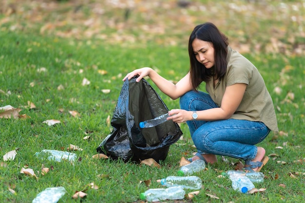 Asiatische Frau hilft bei der Müllabfuhr in der Wohltätigkeitsumgebung