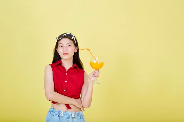 Asiatische Frau im Sommer lässige Kleidung mit einem Glas frischem Fruchtsaft