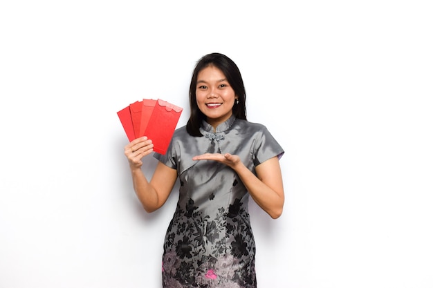 Asiatische Frau Kleid traditionelle Cheongsam tun einige Pose und halten roten Umschlag Angpau
