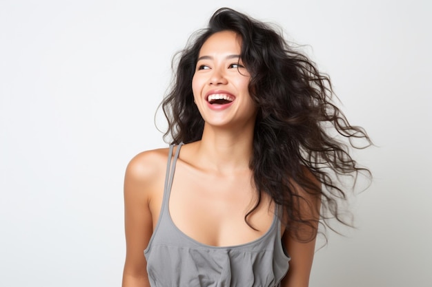 Asiatische Frau lacht glücklich und trägt ein graues Tanktop