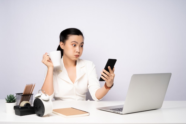 Asiatische Frau macht eine Pause, nachdem sie gearbeitet und Smartphone benutzt hat. isoliert auf weißem Hintergrund.