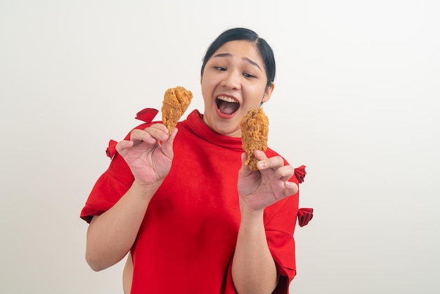 Asiatische Frau mit gebratenem Huhn an Hand