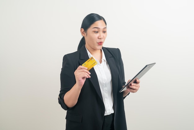 Asiatische Frau mit Kreditkarte und Tablet mit weißem Hintergrund
