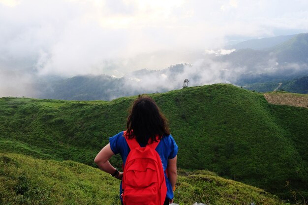 Asiatische Frau mit Ziel und Paradies des goldenen Sonnenaufgangs und Sonnenuntergangs, der zu Nebel und Nebel im Dschungel auf dem Talberg scheint. Luftaufnahme des tropischen Regenwaldes in Thailand.