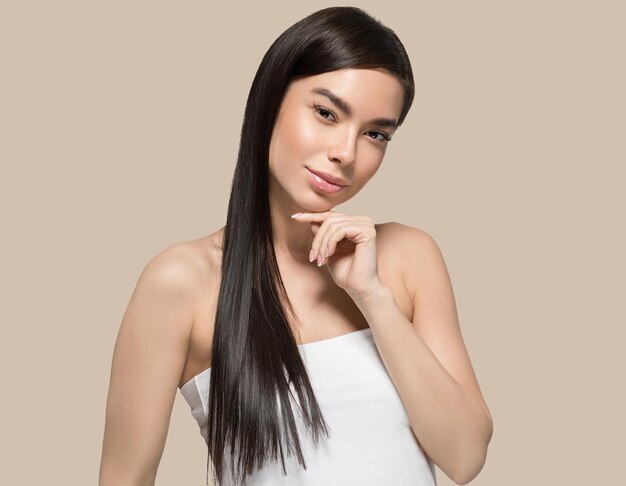 Asiatische Frau Schönheit gesunde Hautpflege und schöne Haare weibliches Modell Porträt Farbhintergrund braun
