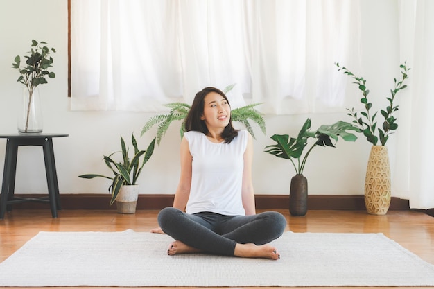 Asiatische Frau sitzt entspannt zu Hause