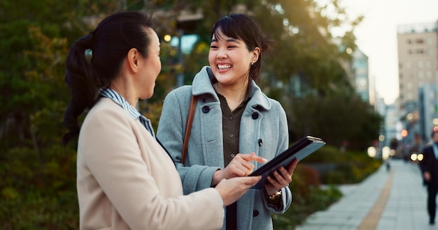 Asiatische Frau Tablet und Team auf dem Bürgersteig in der Stadt für Kommunikationsforschung oder soziale Medien Geschäftsleute lächeln mit Technologie für Online-Such-Chat oder Netzwerk auf dem Gehweg in einer städtischen Stadt