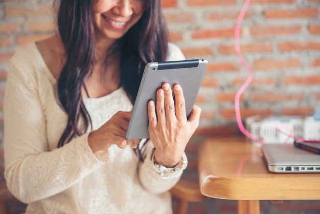 Asiatische Frau Touch-Smart-Tablet-Fokus auf die Hände mit der mobilen App-Home-Office