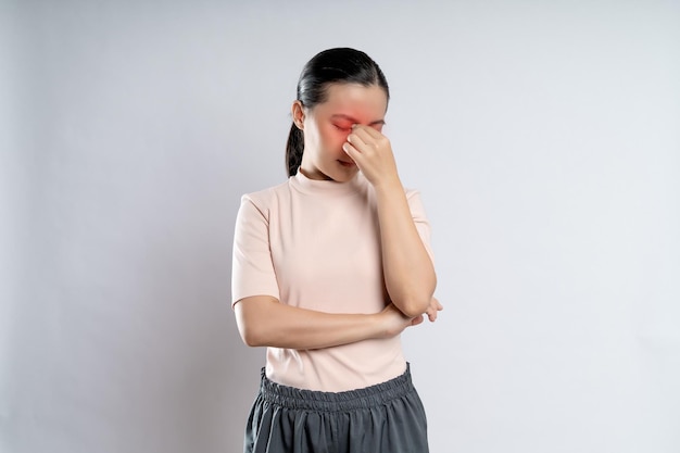 Foto asiatische frau war irritiert, juckte und berührte ihre augen mit einem roten fleck, der isoliert auf weißem hintergrund stand