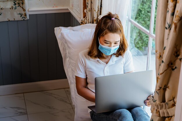 Foto asiatische frau zu hause mit laptop, um produkte online zu verkaufen