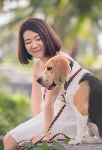 Asiatische Frau zusammen mit Hund als bester Freund. Solo Outdoor-Lifestyle im Park.