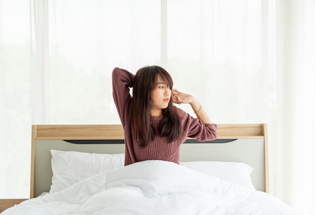 Asiatische Frauen auf dem Bett und morgens aufwachen