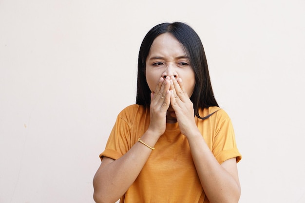 Asiatische Frauen bedecken ihre Hände, wenn sie gähnen