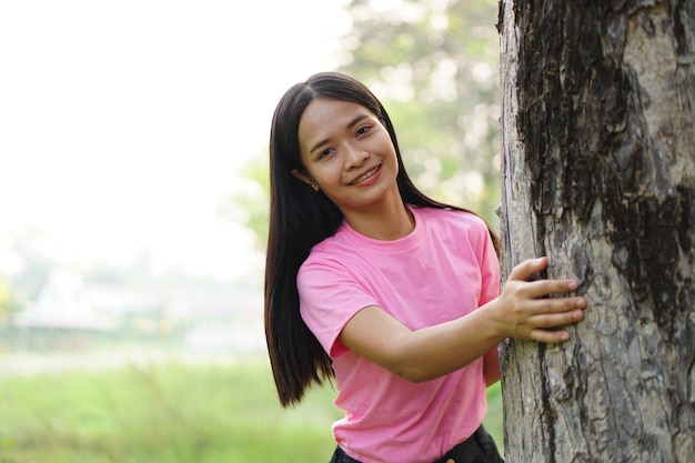 Asiatische Frauen, die Bäume umarmen, das Konzept der Liebe für die Welt