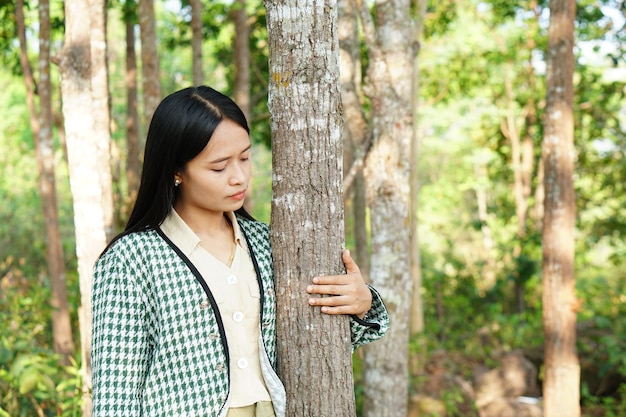 Asiatische Frauen, die Bäume umarmen, das Konzept der Liebe für die Welt
