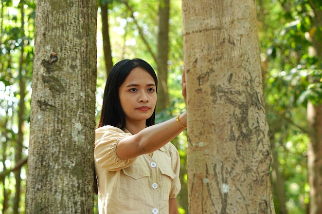 Asiatische Frauen, die das Baumkonzept der Liebe für die Welt umarmen