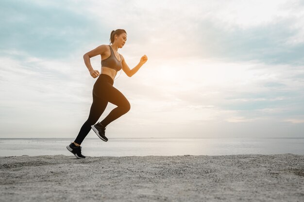 Asiatische Frauen, die morgens im Sand am Strand joggen. Übung, Fitness, Training, Fitnesstraining, Lebensstil und gesundes Konzept.