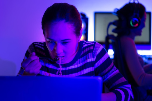 Foto asiatische frauen, die sich stark auf computer verlassen, um dramaserien zu sehen, bis sie essen müssen