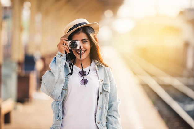 Asiatische frauen lächeln mit kamerareise urlaub am bahnhof mit reisender entspannung.