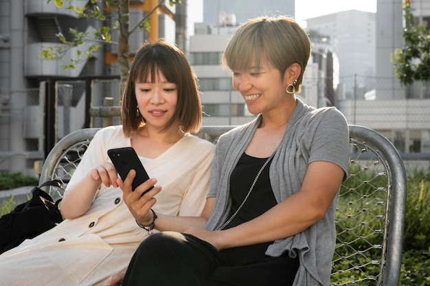 Asiatische Frauen schauen sich etwas am Telefon an