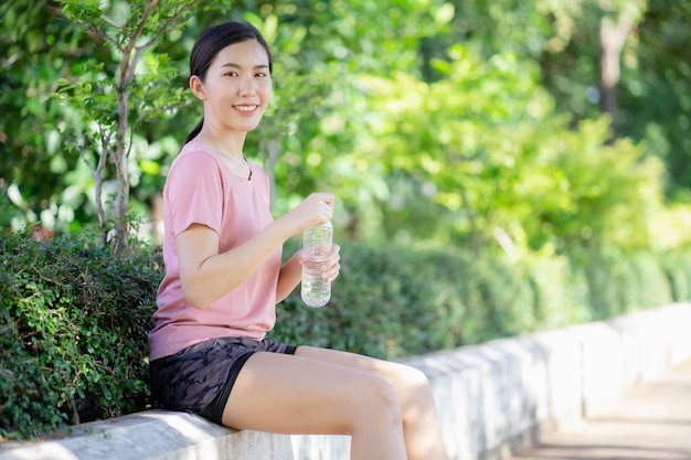 Asiatische Frauen trinken Wasser nach dem Sport
