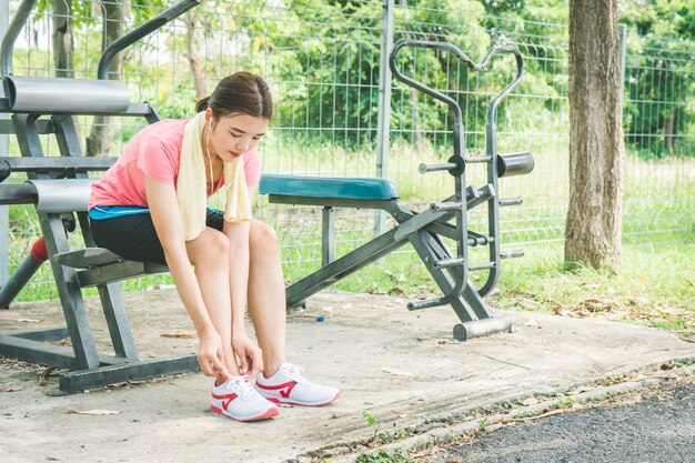 Asiatische Frauen ziehen ihre Schuhe vor dem Joggen an.