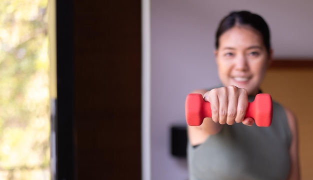 Asiatische Frauenübung mit anhebender Hantel zu Hause Persönliches Training Routine plant Übungen