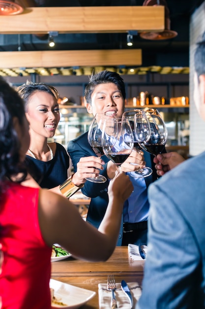 Asiatische Freunde, die mit Rotwein in der Bar rösten