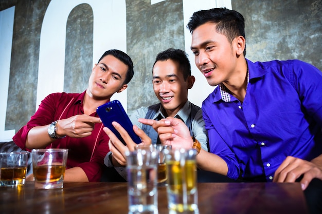 Asiatische Freunde, die Schüsse im Nachtklub trinken