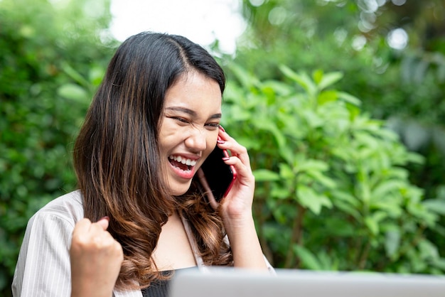 Asiatische Geschäftsfrau benutzt ein Mobiltelefon